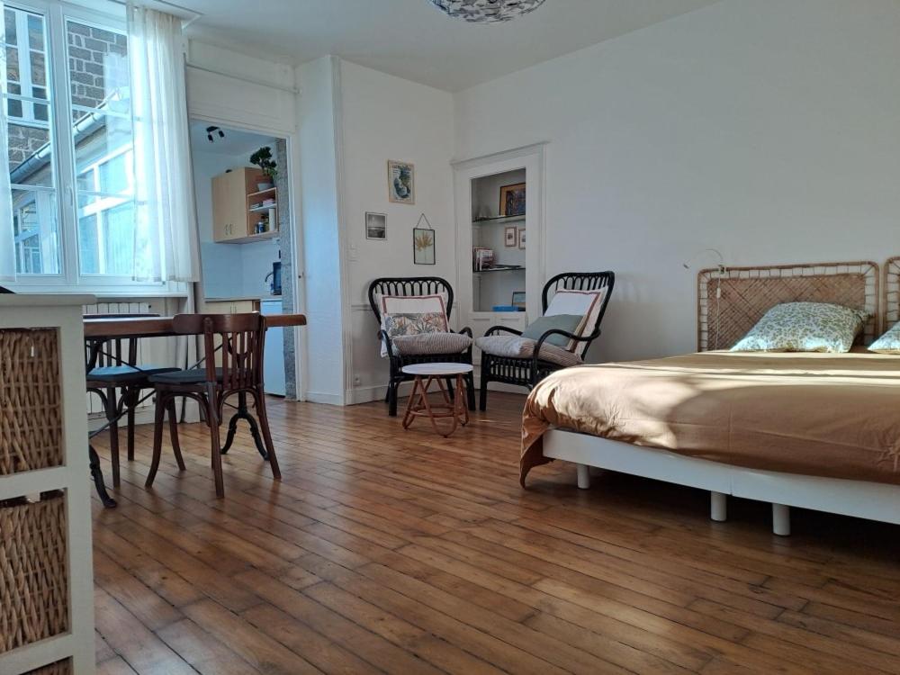 a bedroom with a bed and a table and chairs at Studio plein centre in Dol-de-Bretagne
