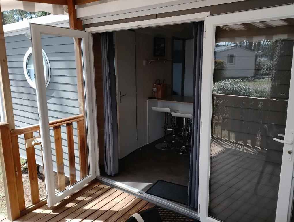 an open sliding glass door on a deck at MH 285 O'HARA 3 chambres et 1 salle de bain dans camping 4 étoiles in Saint-Julien-en-Born