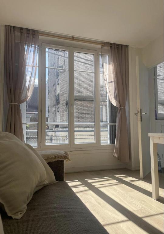 une chambre avec un lit et une grande fenêtre dans l'établissement Appartement 2 pièces 42m2 - Puces de Saint-Ouen, à Saint-Ouen