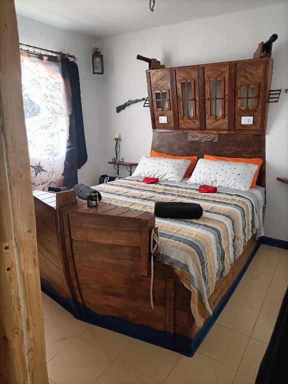 a bedroom with a large bed with a wooden headboard at Ocean Pirate in Costa de Antigua