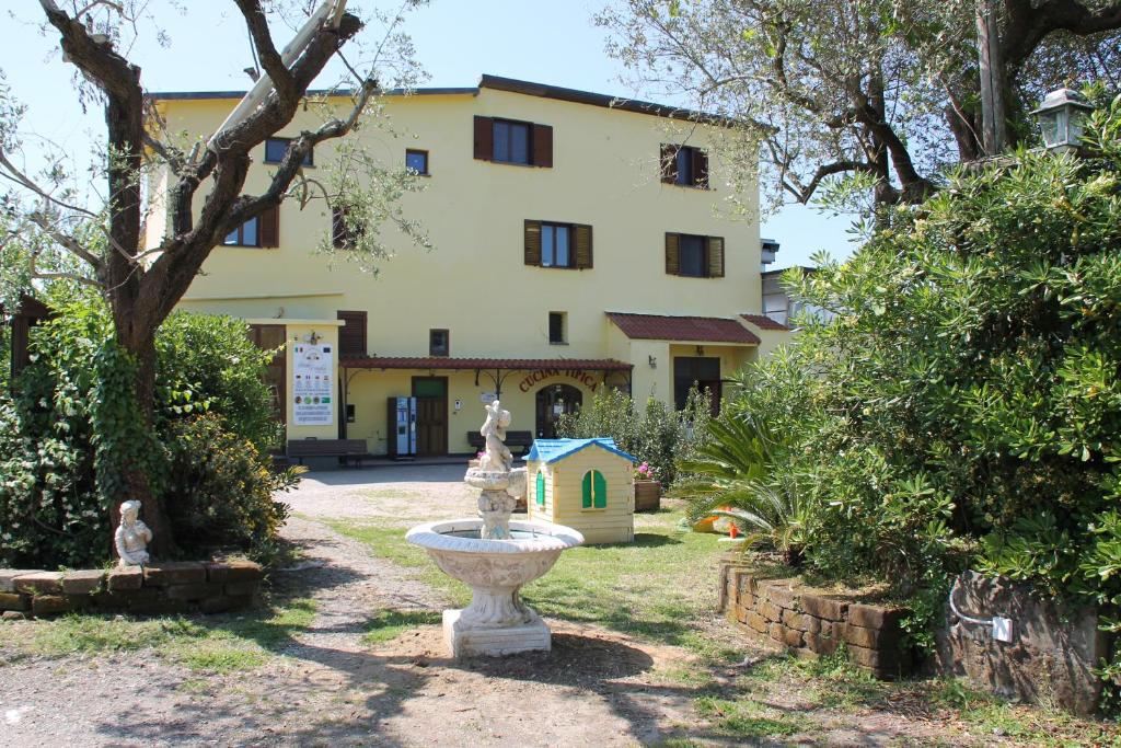 un jardín con una fuente frente a un edificio en Agriturismo Piccolo Paradiso en Piano di Sorrento