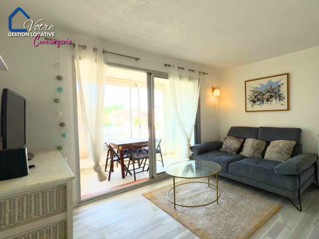 un salon avec un canapé et une table dans l'établissement Le Roy Soleil de la Méditerranée, à Canet