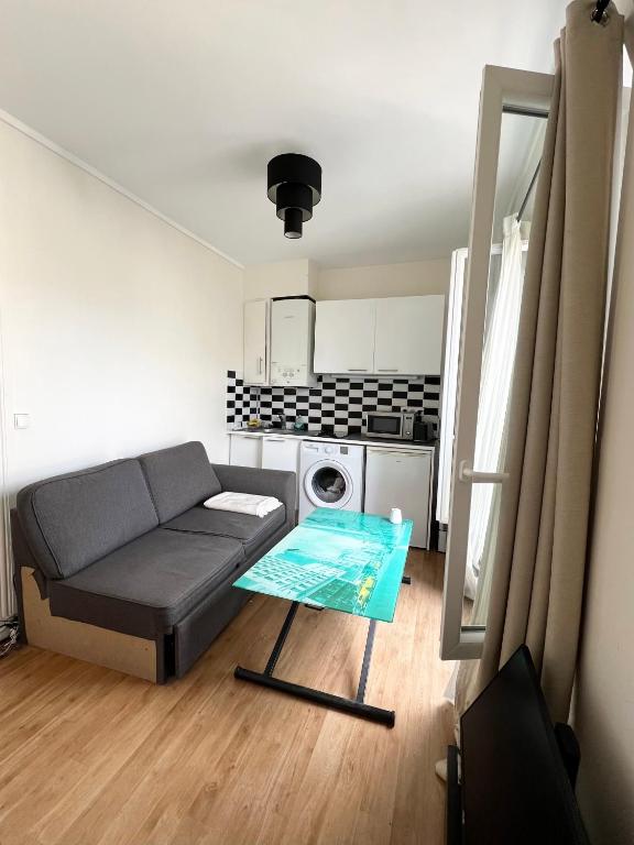 un salon avec un canapé et une table dans l'établissement Appartement Saint Ferdinand, à Paris