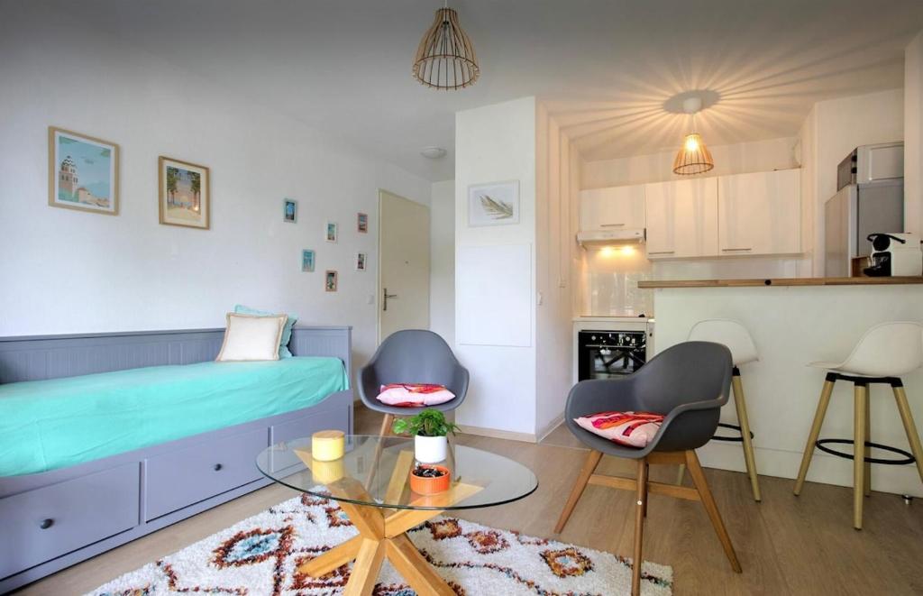 Cette chambre comprend un lit, deux chaises et une table. dans l'établissement Appartement Lumineux et Calme, à Capbreton