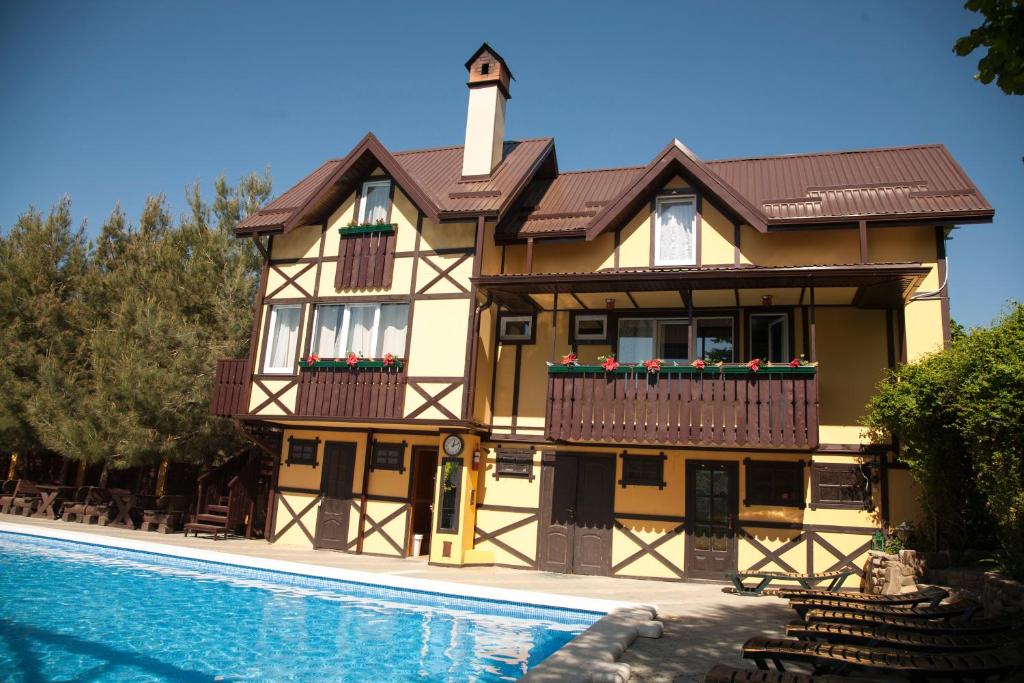 uma casa com uma piscina em frente em Baden Baden Butik Hotel em Arkhipo-Osipovka