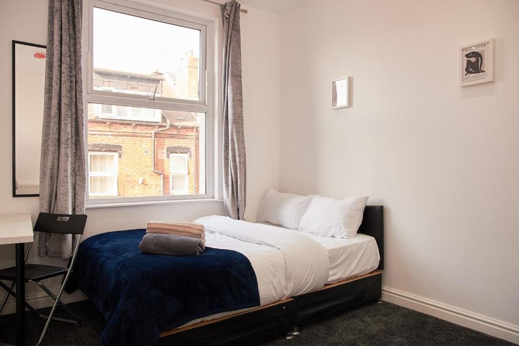 a small bedroom with a bed and a window at West Yorkshire Stay - Heart of Leeds in Roundhay