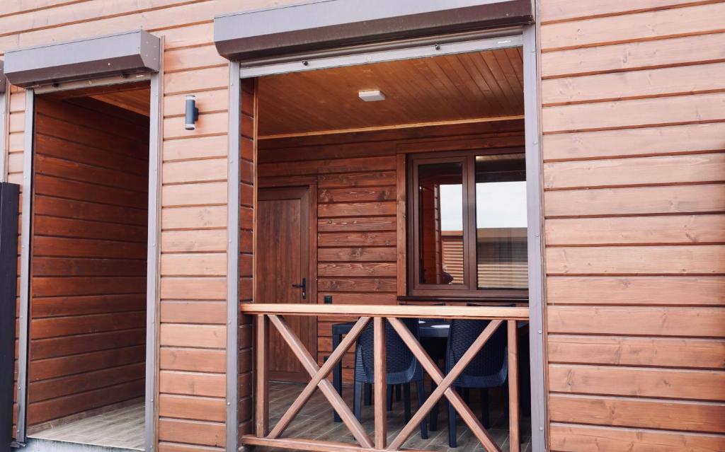 a wooden cabin with a wooden table in the doorway at Тиха Хвиля in Gribovka