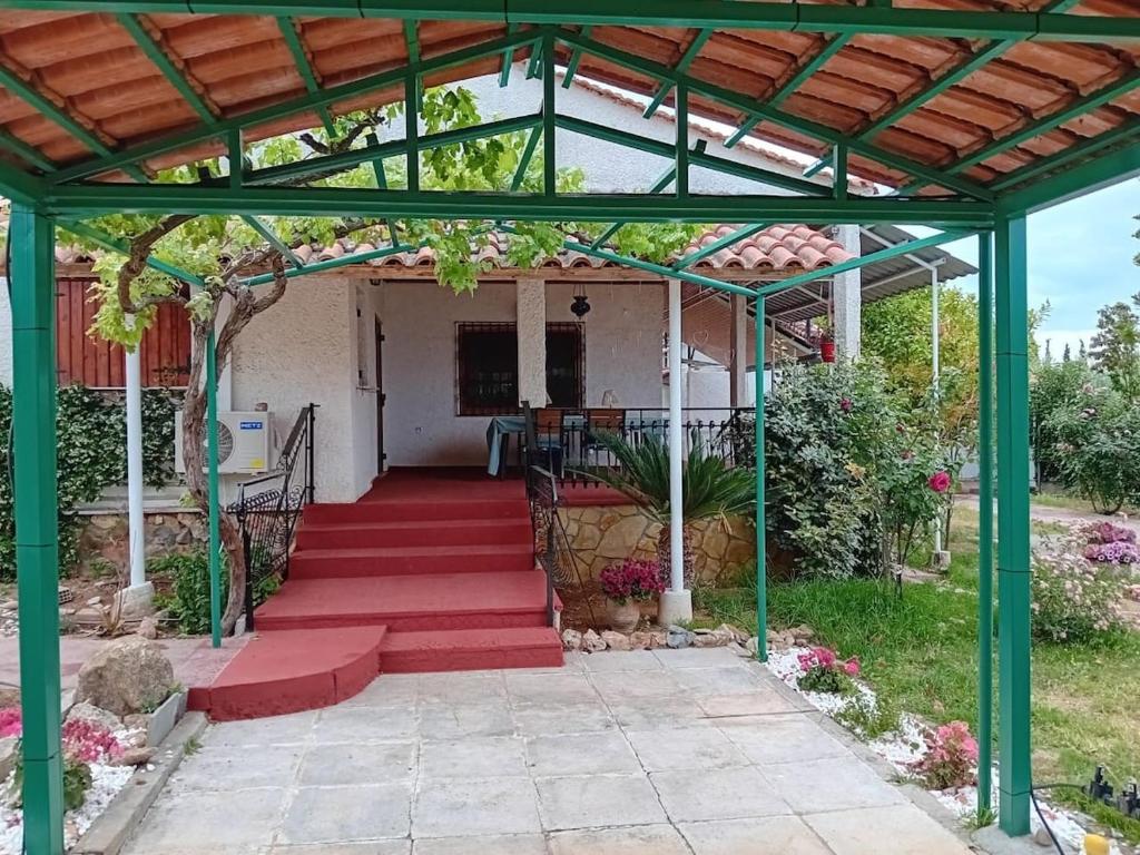 a pergola with red steps leading to a house at Private house near Amarynthos, Evia, Greece in Amarinthos