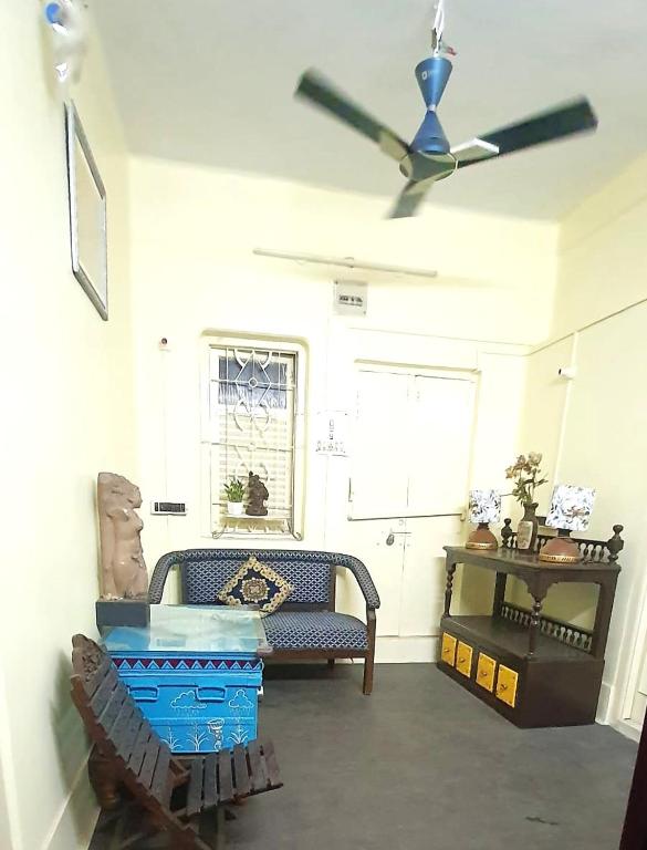 a living room with a ceiling fan and a couch at Mandira's Home in Kolkata
