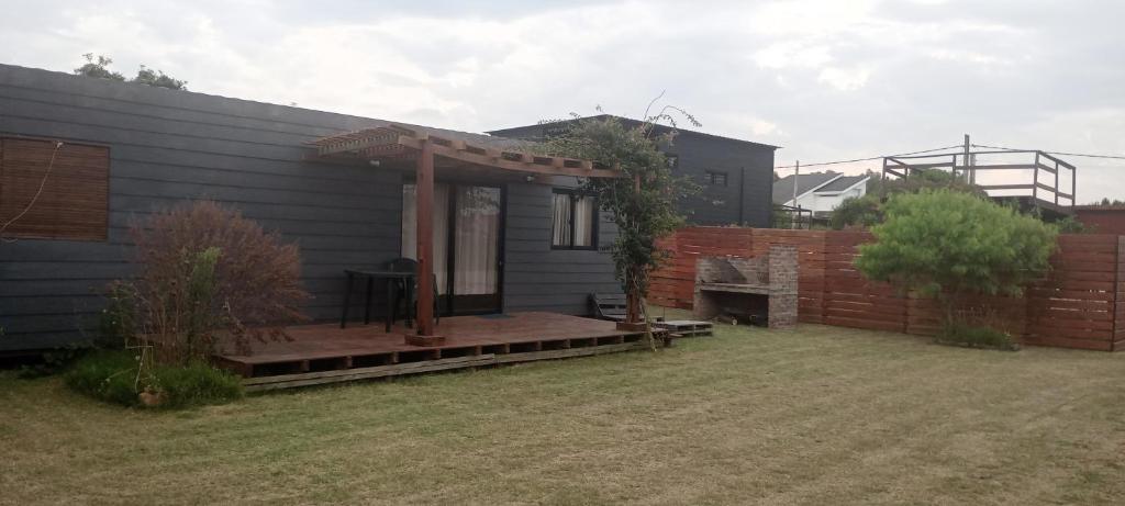 a house with a wooden deck next to a fence at PUNTA NEGRA DISFRUTABLE TODO EL AÑO! in Punta Colorada
