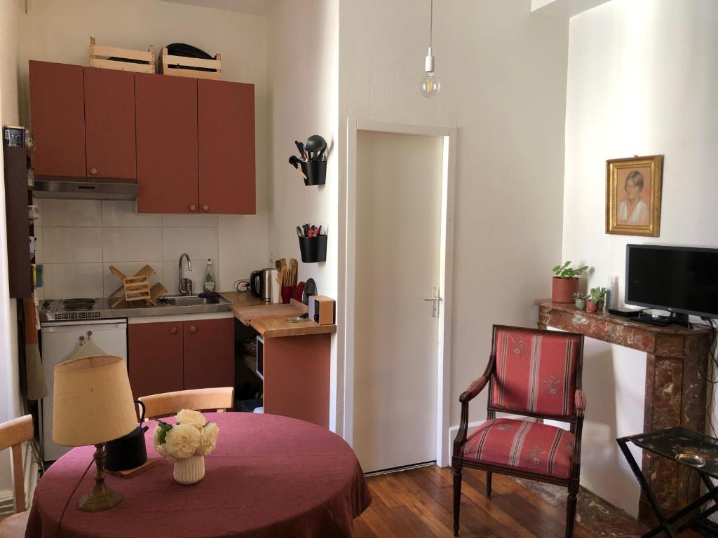 a small kitchen with a table and a red chair at Petit appartement douillet, centre historique de Dijon in Dijon