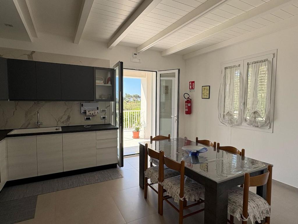 Una cocina y un comedor con mesa y sillas. en Casa Dei Gelsi, en Pozzallo