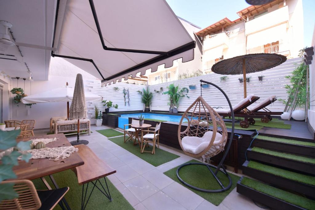 a patio with a swing and a swimming pool at Retro luxury rooms in Olympic Beach