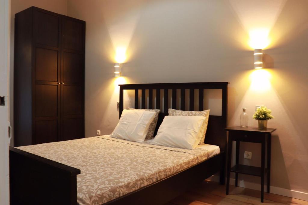 a bedroom with a bed with two pillows and two lights at myApartment in Lisbon