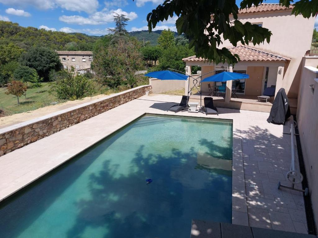 een zwembad in een tuin met een huis bij studio and large, beautiful pool in Saint-Ambroix