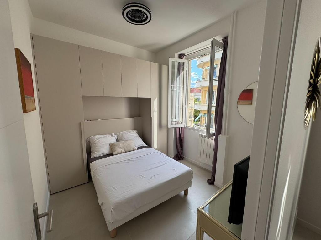 une petite chambre avec un lit et une fenêtre dans l'établissement Ambassador Promenade !, à Nice