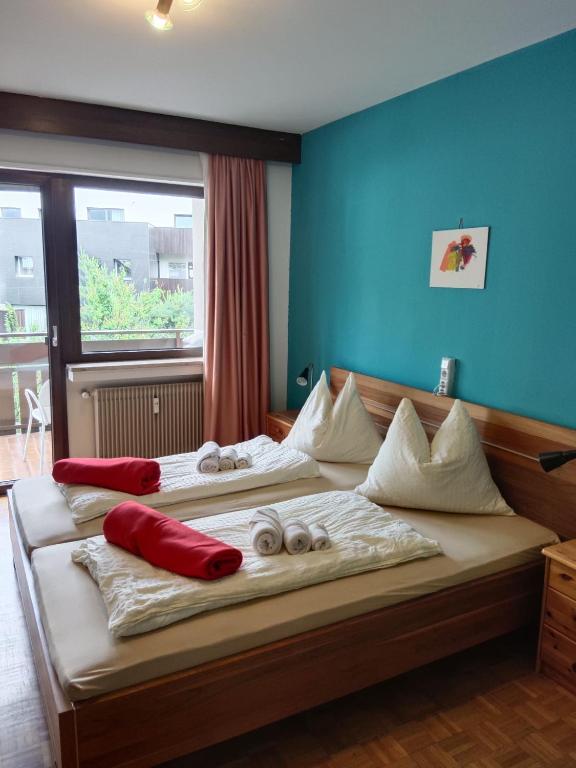 a bedroom with two beds with red pillows on them at Plose Appartements in Bressanone
