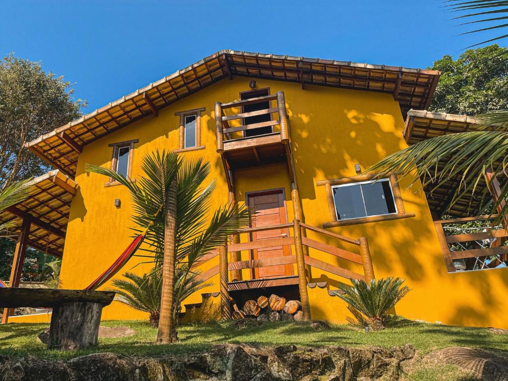 a yellow house with a palm tree in front of it at Casa O Segredo da Alma in Sana