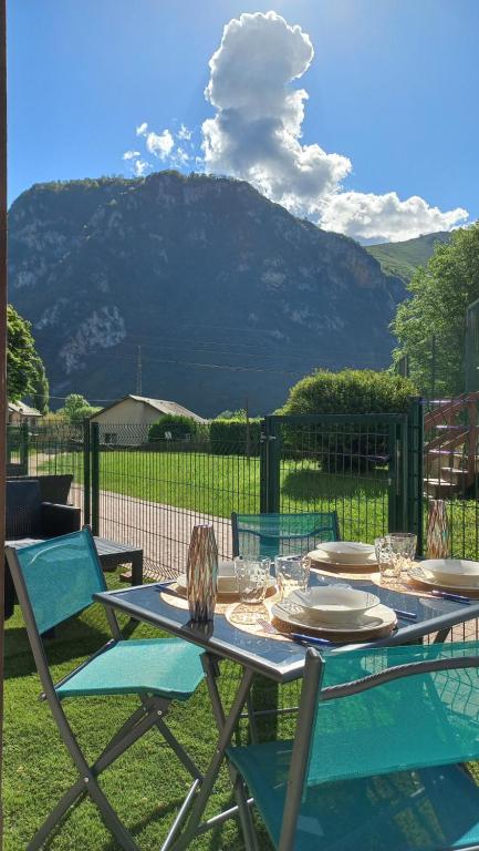 a table and chairs with a view of a mountain at Les Epicuriens in Bielle