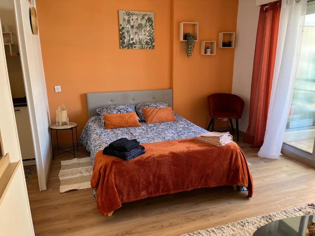 une chambre avec un lit avec un mur orange dans l'établissement Studio proche promenade des anglais, à Nice