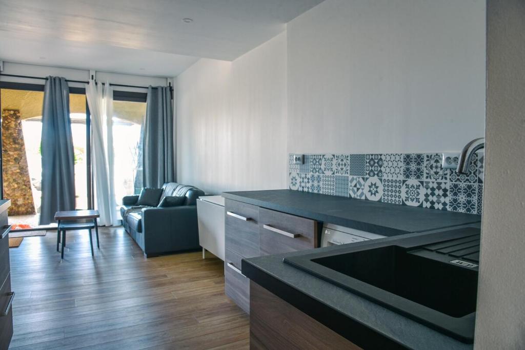une cuisine avec un comptoir et un salon dans l'établissement Appartement cosy proche océan, à Seignosse