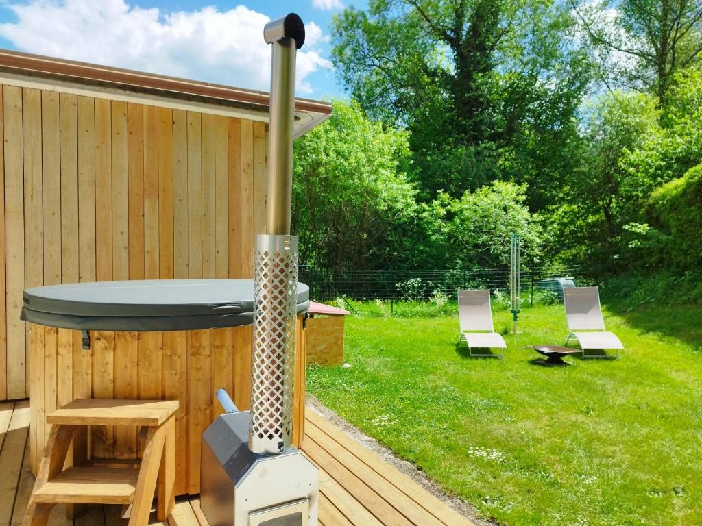 podwórko z wanną z hydromasażem i 2 krzesłami w obiekcie Domaine de Marmonfosse w mieście Taintrux