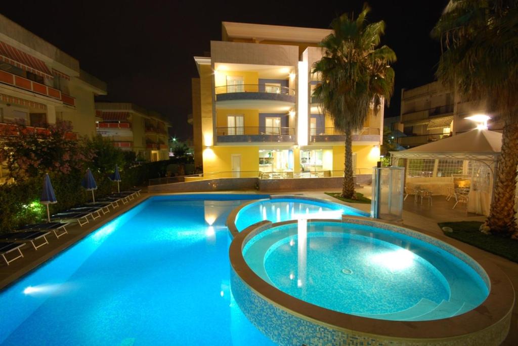 una grande piscina di fronte a un edificio di notte di Mare Blu Residence a Martinsicuro