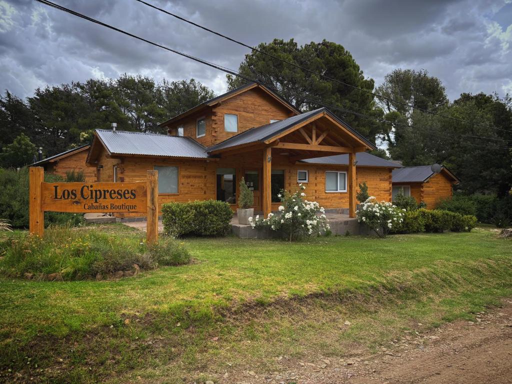 a house with a sign in front of it at Cabañas Boutique Los Cipreses in Villa Ventana