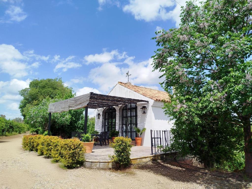 a small white chapel with a cross on the roof at Casa Rural del Guadalora in Hornachuelos