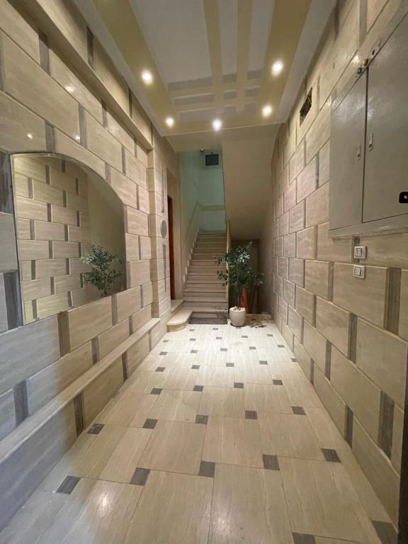 an empty hallway with a stone wall and stairs at Luxe Nest Guest House Apartment 102 in Luxor
