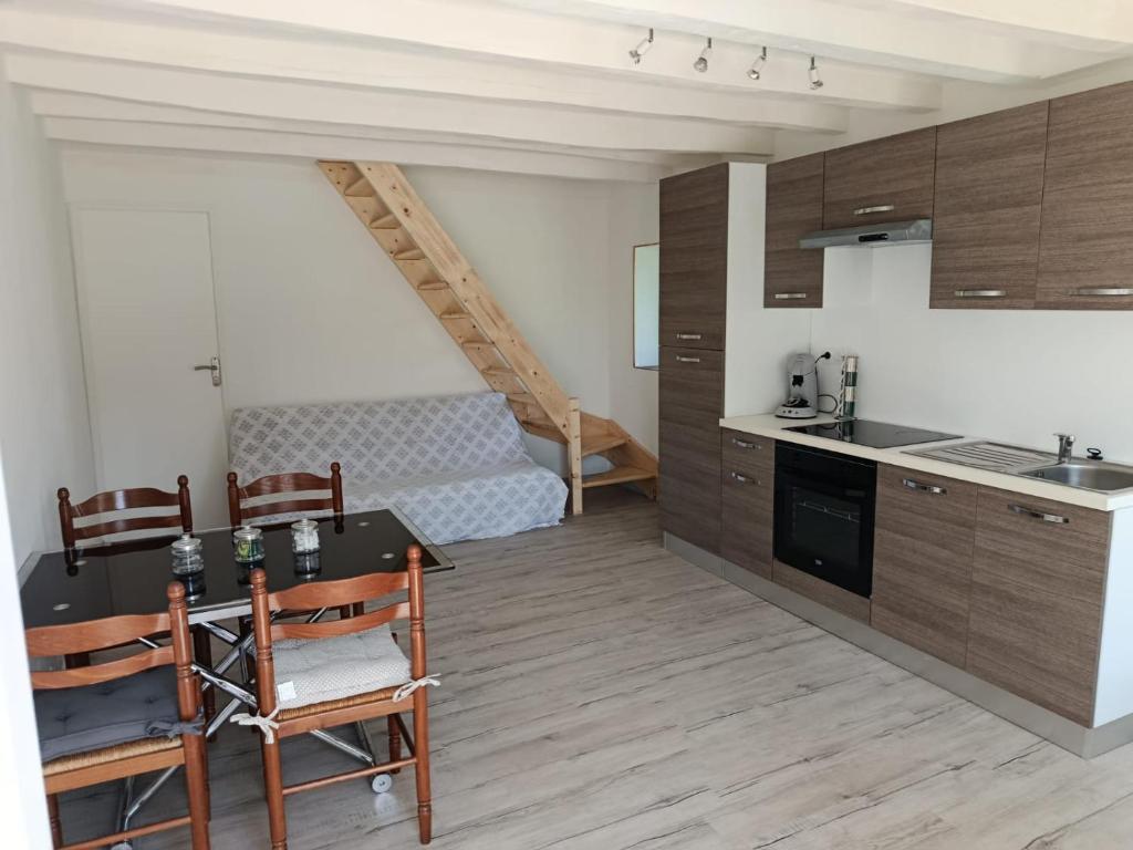 une cuisine avec une table et des chaises dans une pièce dans l'établissement Petite maison à la campagne, à Faverolles