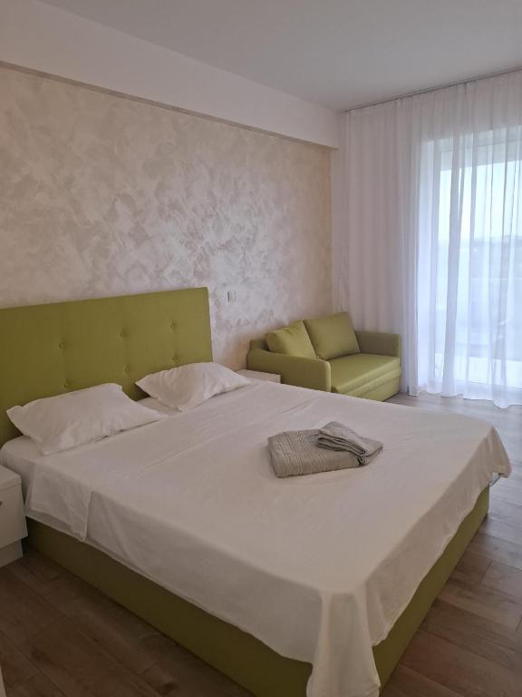 a bedroom with a large bed and a yellow chair at My Blaxy apartment in Olimp