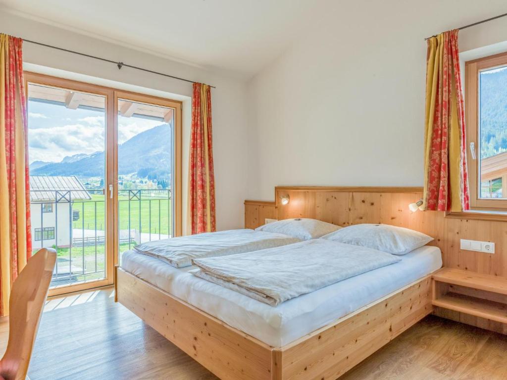 sypialnia z łóżkiem i dużym oknem w obiekcie Next To The Skilift A 5 w mieście Brixen im Thale