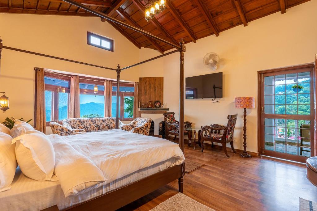 穆克缇斯瓦Stone Heritage Mukteshwar的一间卧室，里面有一张床、一张桌子和几把椅子。