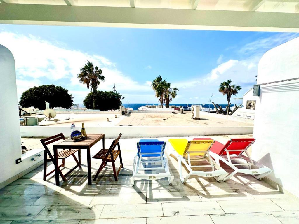 a patio with chairs and a table with a view of the beach at Michas House in Puerto del Carmen