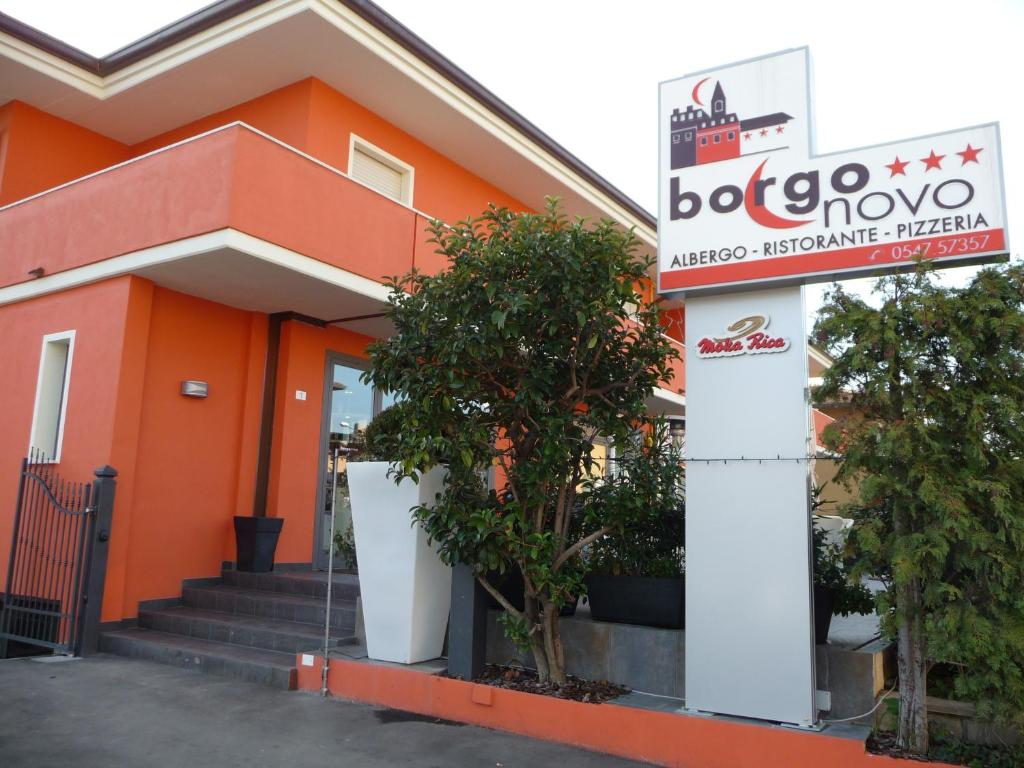 an orange building with a sign in front of it at Albergo Borgonovo in Badia