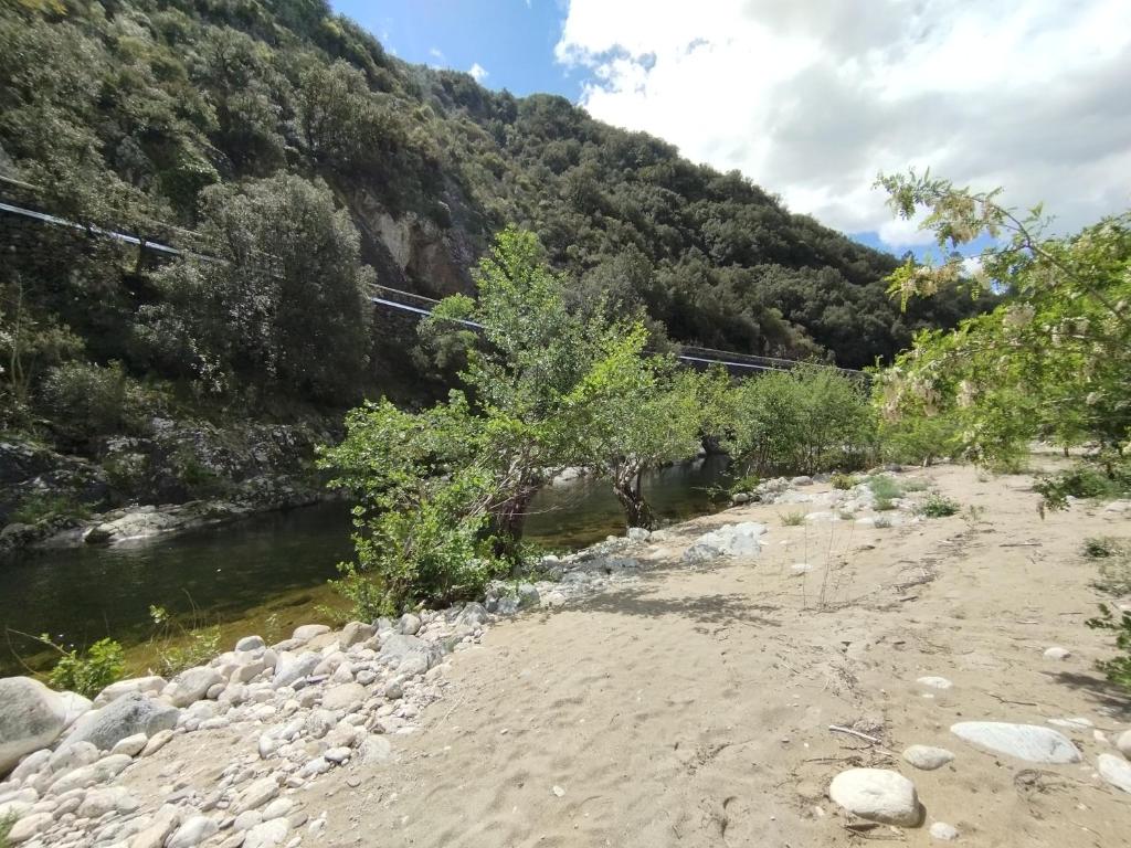 un pont sur une rivière à côté d'une montagne dans l'établissement Tiny house bord de rivière, à Beaumont