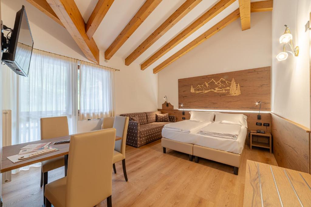 sypialnia z łóżkiem i biurkiem w pokoju w obiekcie Pineta Pastry Hotel w mieście Rocca Pietore