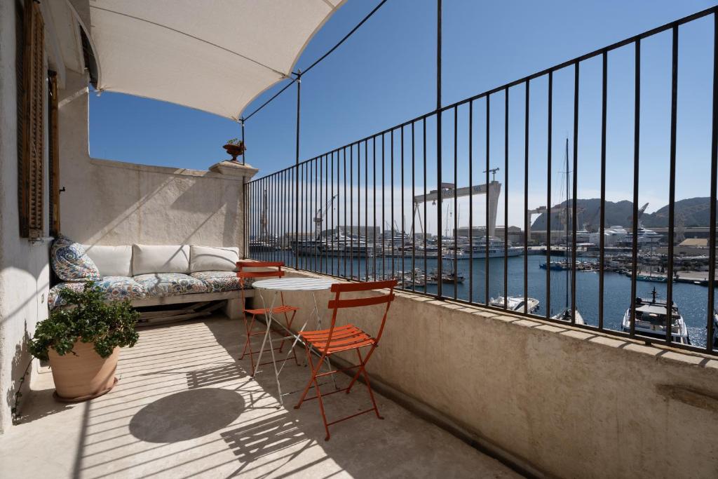 Panorama vue mer et plein centre ville في لاسيوتا: شرفة مع طاولة وكراسي وإطلالة على الميناء