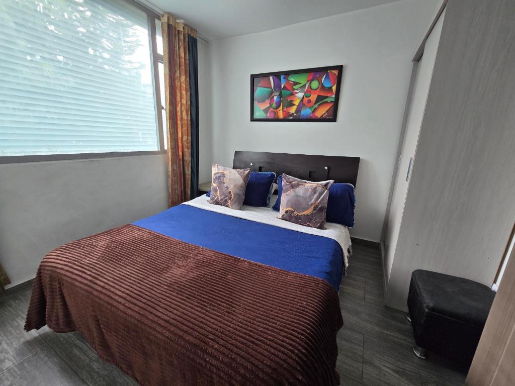 a bedroom with a large bed with a window at Apartamento Portal el Dorado, a solo 5 min del aeropuerto, vias, cll 26 in Bogotá
