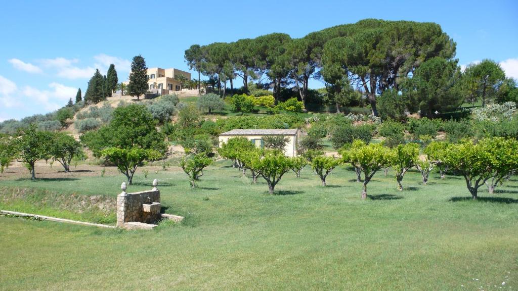 a field with trees and a house on a hill at Tenuta Bartoli Maison de Charme in Mazzarino