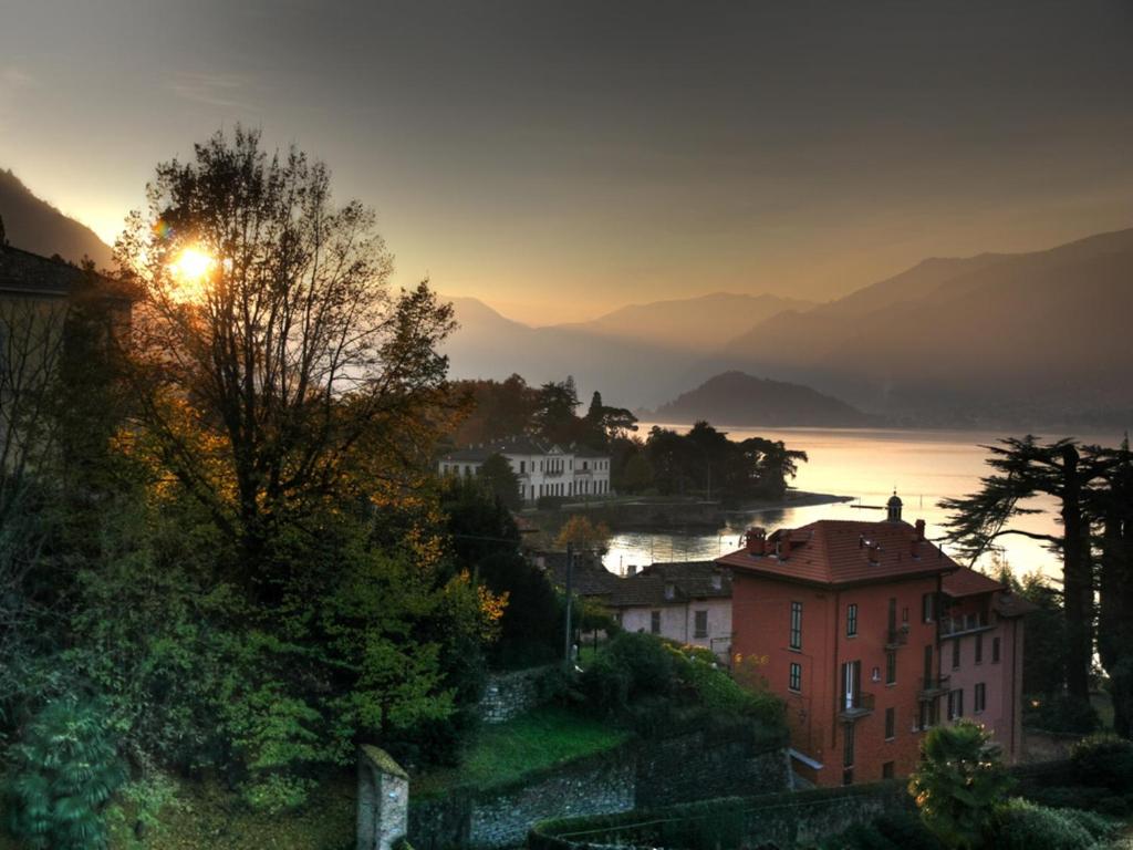 a view of a town with the sun setting over the water at Tablinum in Bellagio