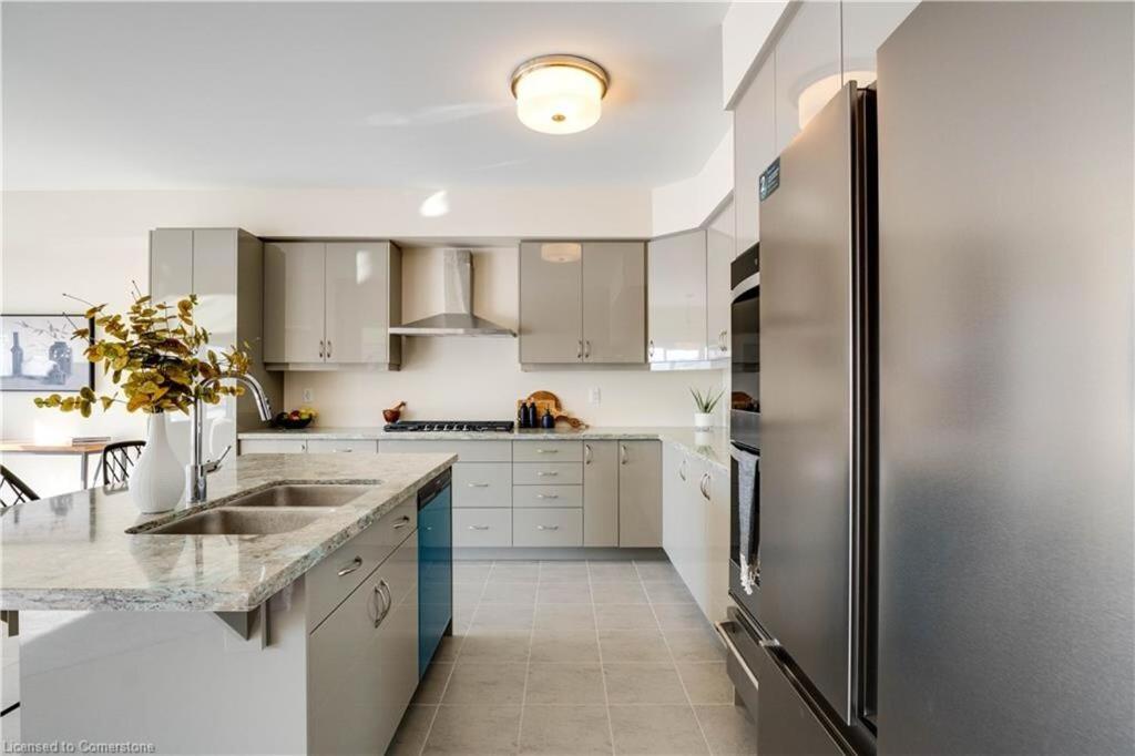 a kitchen with white cabinets and a stainless steel refrigerator at Luxury 5 Bed Retreat for 12 with Gourmet Kitchen in Paris