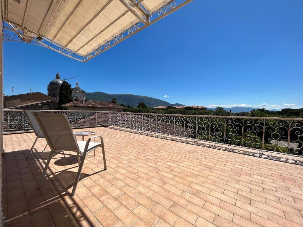 a chair sitting on a patio with a balcony at La Terrazza degli Angeli Guest House in Santa Maria degli Angeli