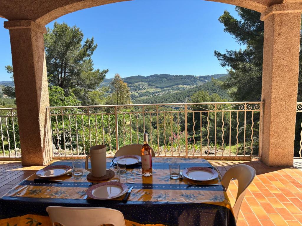 - une table sur une terrasse couverte avec vue sur les montagnes dans l'établissement -Villa les Pins- Bandol, à Bandol
