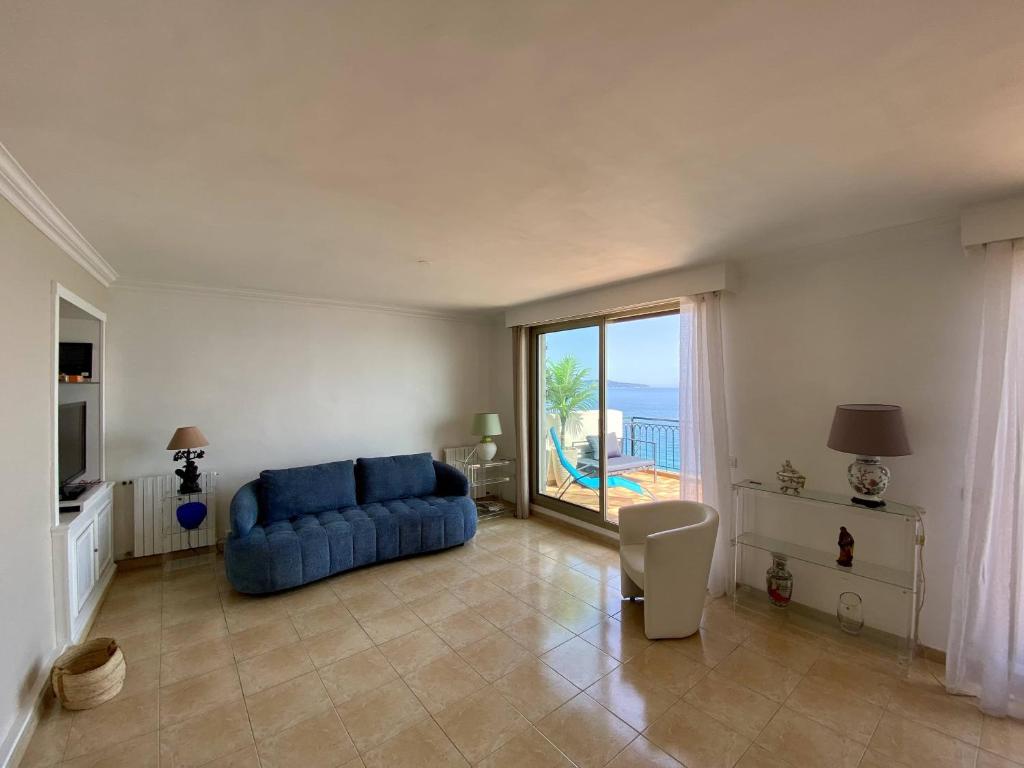un salon avec un canapé bleu et une grande fenêtre dans l'établissement NICE 2P Panoramic Sea View Wi-Fi AC, à Nice