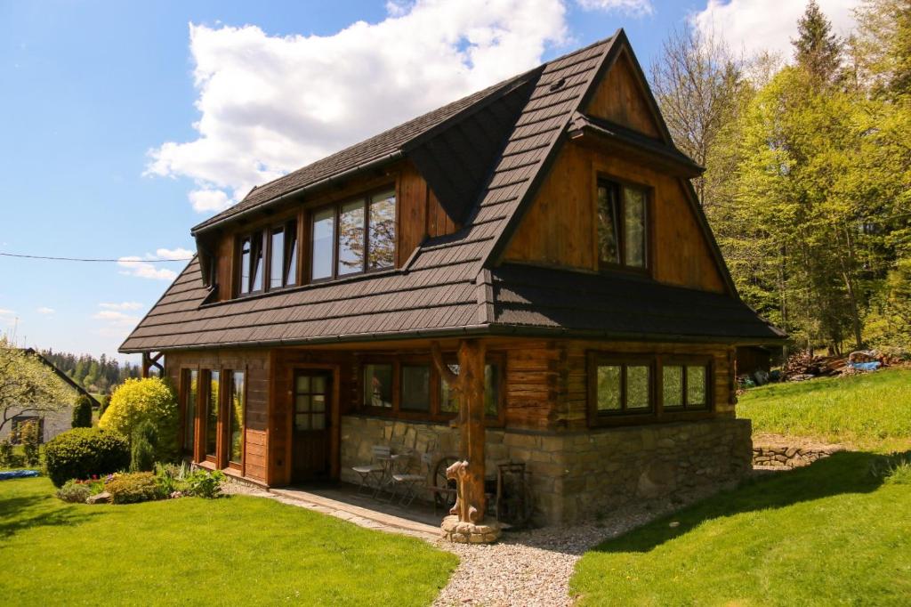 a wooden house with a gambrel roof at Buflaczanka in Nowy Targ