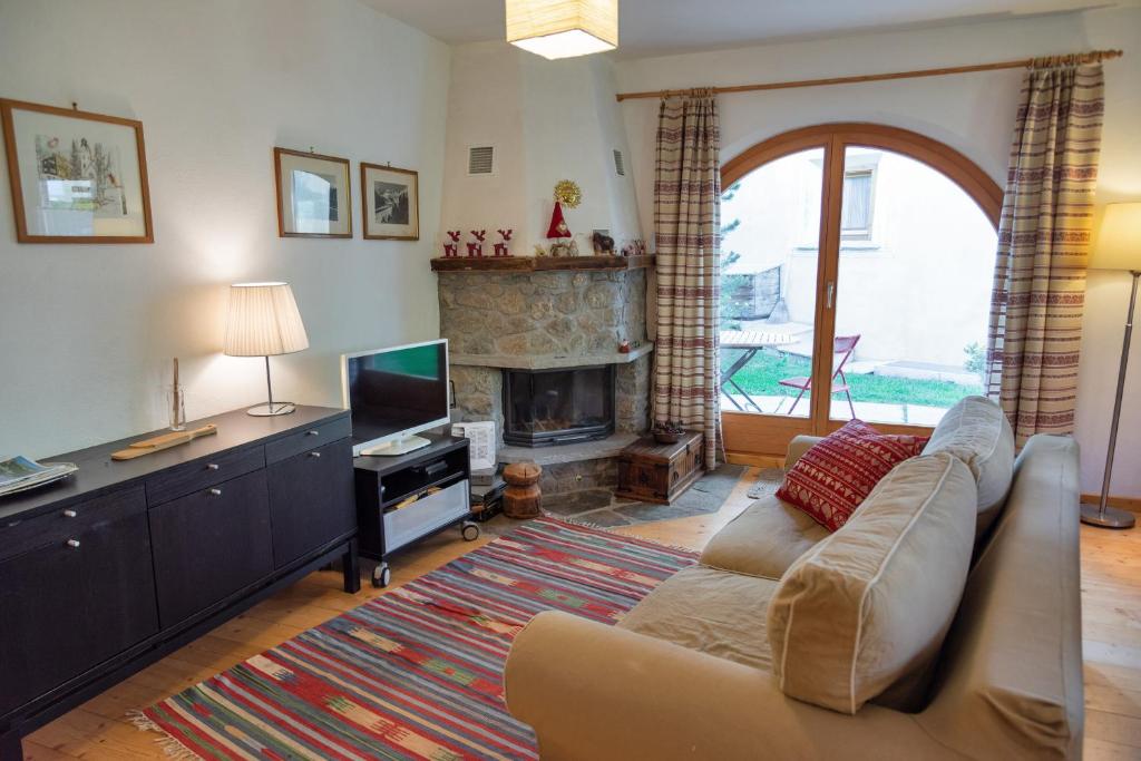 a living room with a couch and a fireplace at Chesa Filia - La Punt in La Punt-Chamues-ch
