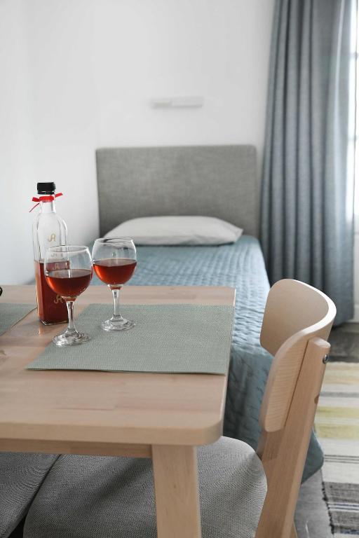 two glasses of wine on a table in a bedroom at On Sight Studio l in Myrties