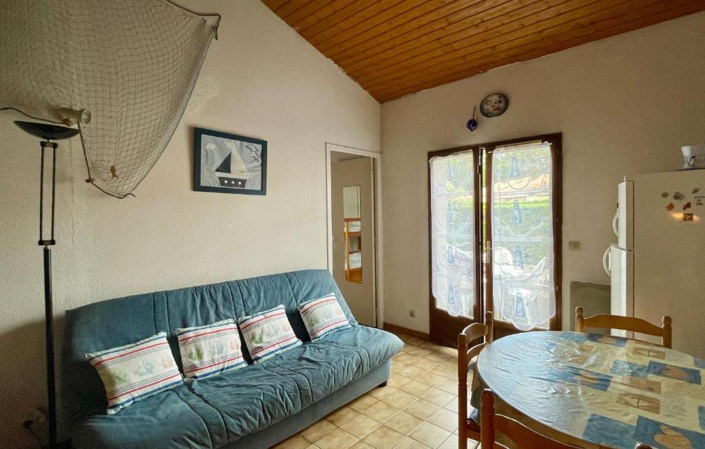 un salon avec un canapé bleu et une table dans l'établissement Duplex house B34 Les Villas de La Palmyre, aux Mathes